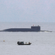 In this Aug. 28, 2014 photo, fishermen look at a Chinese nuclear submarine sails past Yalong Bay in Sanya, south China’s Hainan Province. Several Asian nations are arming up, their wary eyes fixed squarely on one country: a resurgent China that’s boldly asserting its territorial claims all along the East Asian coast. The scramble to spend more defense dollars comes amid spats with China over contested reefs and waters. Other Asian countries such as India and South Korea are quickly modernizing their forces, although their disputes with China have stayed largely at the diplomatic level. (AP Photo/Andy Wong)